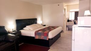 Cette chambre comprend un lit et un réfrigérateur. dans l'établissement Simple Rewards Inn, à Île de Hilton-Head