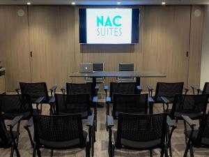 una sala conferenze con sedie e tavolo con un cartello con un cartello di suite nac di NAC SUITES a Porpetto
