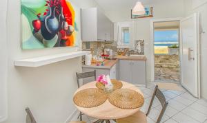 a kitchen with a table with chairs and a painting at Sea La Vie in Skala Rachoniou