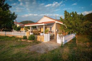 a house with a white fence in a yard at Sea La Vie in Skala Rachoniou
