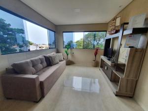 uma sala de estar com um sofá e 2 janelas grandes em CASA VISTA MAR SÃO JOSÉ ANTUNES MARAGOGI em São José da Coroa Grande