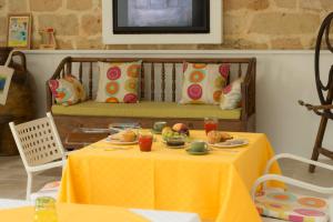 a table with plates of food on it with a bench at Masseria La Tofala benessere & SPA in Copertino