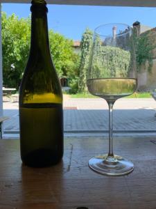 a bottle of wine next to a glass on a table at NAC SUITES in Porpetto