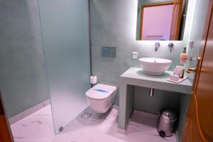 a bathroom with a toilet and a sink and a mirror at Tinos Koralli in Tinos