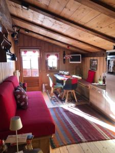 a living room with a red couch and a table at Chalet Sappada in Sappada