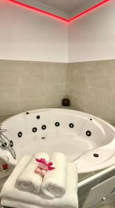 a white bath tub with towels and a pink flower on it at El Castillo in Alcalá de Guadaira