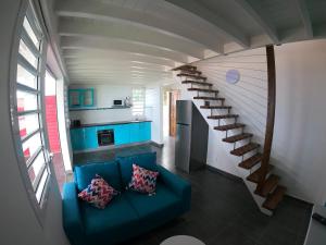 sala de estar con sofá azul y escalera de caracol en Gîte Passion Kréyol, Vue mer et montagne, SPA privé en Vieux-Habitants