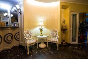 a room with two chairs and a table and a lamp at Hotel Helin Central in Craiova