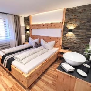 ein Schlafzimmer mit einem großen Bett mit einem Holzrahmen in der Unterkunft Apart ZIRMZEIT in Huben