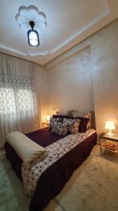 een slaapkamer met een groot bed en een kroonluchter bij Yasmine in El Jadida
