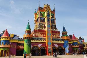 un edificio de un castillo de Disney con gente caminando alrededor de él en Casa Oliveira 2, en Penha