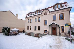 a large white house with snow on the ground at Apartamenty AP 10 in Częstochowa