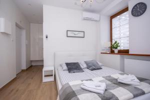 a bedroom with a bed and a clock on the wall at Apartamenty AP 10 in Częstochowa