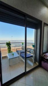 a living room with a view of the ocean from a window at Yasmine in El Jadida