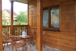 patio ze stołem i krzesłami na ganku w obiekcie Chatka z Góralskim Klimatem w Żywcu