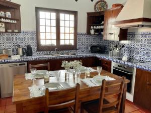 une cuisine avec une table en bois avec deux chaises et une table dans l'établissement Super Mário Houses - Casa dos Moinhos, à Porto Formoso