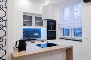uma cozinha com armários brancos e um aparelho preto em Apartament w samym sercu Opola 3 em Opole