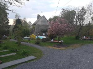 een tuin met een huis en een tuin met een boom bij LA ROULOTTE DE GERMAINE in Condé-sur-Vire