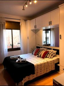 ロスピタレート・デ・リョブレガートにあるLuminosa habitación con aire acondicionadoのベッドルーム1室(黒い毛布と枕付きのベッド1台付)