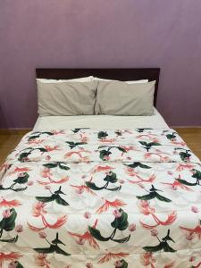 - un lit avec un couvre-lit floral dans l'établissement استراحة الماس, à Umm Lajj