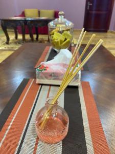 烏姆拉吉的住宿－استراحة الماس，带有筷子和玻璃瓶的桌子,有紫禁 ⁇ 的杜 ⁇ 