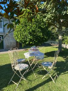 einen Tisch und Stühle im Gras mit einem Tisch in der Unterkunft Casal da Batoca Nature House in Fafe