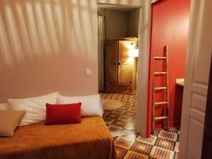 - une chambre avec un lit doté d'un oreiller rouge dans l'établissement LA TERRASSE VIGNERONNE, à Fitou