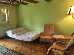 sypialnia z łóżkiem, krzesłem i stołem w obiekcie Agroturystyka Niezapominajka w mieście Kosewo