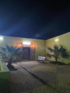 a building with two palm trees in front of a door at استراحة الماس in Umm Lajj