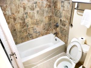 uma casa de banho com uma banheira branca e um WC. em Simple Rewards Inn em Hilton Head Island