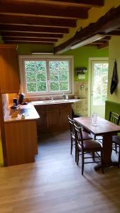 a kitchen with a wooden table and a dining room at La Faisane in Gueschart