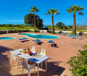a table and chairs in front of a pool at Agroestancia Lloc Nou en Ciutadella de Menorca in Ciutadella