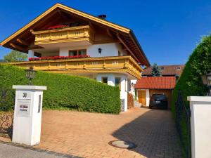 een wit huis met een dak met bloemen erop bij Ferienwohnung mit Bergblick in Unterammergau