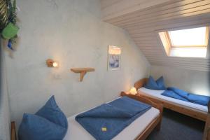 two beds in a small room with blue pillows at Heutauer Hof in Siegsdorf