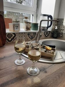 - deux verres de vin assis sur un comptoir à côté d'un évier dans l'établissement La Parenthese Bois de Cise, à Ault