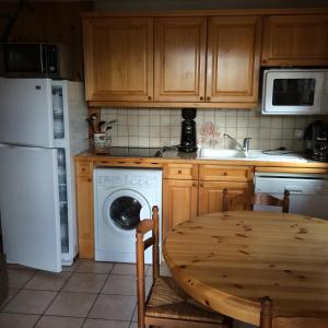 cocina con mesa de madera y lavavajillas blanco en Manon, en Hauteluce 1 foto más
