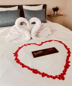 una torta a forma di cuore con due cigni e asciugamani di Apartman Mares a Krk