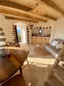 ein Wohnzimmer mit einem Tisch und einem Sofa in der Unterkunft Tour Génoise Micalona, Domaine de l'Oglisatru in Olmeto