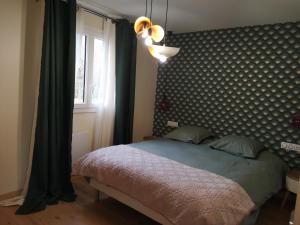 sypialnia z łóżkiem ze wzorzystym zagłówkiem i oknem w obiekcie La cachette d'Anne-Charlotte (jardin, parking dans la campagne Honfleuraise) w mieście Fourneville