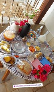 una mesa cubierta con platos de pan y otros alimentos en Beach house Suites, en Jericoacoara