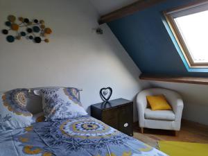 a bedroom with a bed and a chair and a window at GITE DE LA BUTTE le charme de la Normandie entre Terre et Mer in Condé-sur-Vire