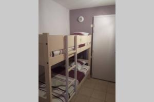 a bunk bed room with two bunk beds and a door at Studio lumineux idéalement situé (golf et plage). in Moliets-et-Maa