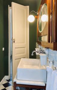 Un baño con un lavabo blanco y un espejo. en Living Suite Catania Ursino, en Catania