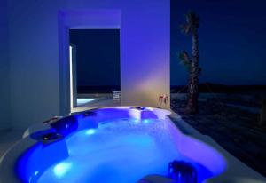 a blue bath tub in a room with a palm tree at Seashore Beachfront Villa in Lachania