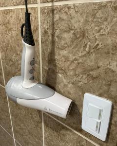 a white electric hair dryer hanging on a wall at Mirians Place Drake in Drake