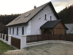 une maison blanche avec une clôture en bois devant elle dans l'établissement Chalupa U Berušek, à Oskava