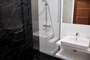 a white bathroom with a sink and a shower at Wilanów Apartment close to Town Hall and Palace in Warsaw +10 photos