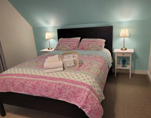 a bedroom with a large bed with a pink bedspread at La Maison de Sophie in Niagara-on-the-Lake