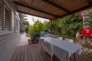 a patio with a table and chairs on a wooden deck at רגע ערבה in ‘En Yahav
