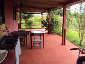 a patio with a table and chairs in a house at Sitio Sao Benedito in São Roque de Minas